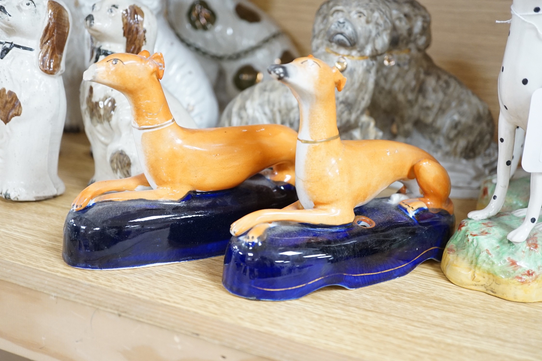 A mixed collection of mostly Staffordshire pottery models of recumbent dogs, hounds, etc. to include Dalmatians- 19.5cms high
